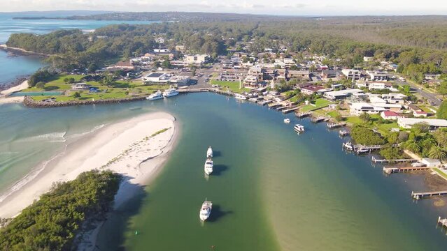 Aerial drone view of Huskisson in the City of Shoalhaven on the shores of Jervis Bay, NSW, Australia, showing Currambene Creek on a bright sunny morning   