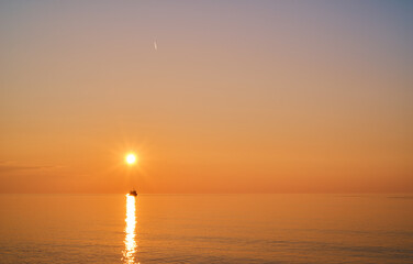 sunset over the sea with a boat
