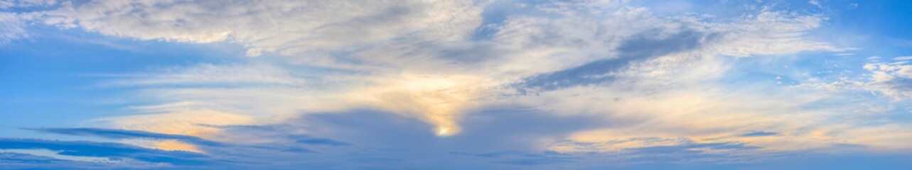 Panorama von einem blauen Himmel mit Sonne und Wolken