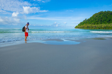 A lonely male tourist strolling along a beautiful beach in the tropical sea of ​​Thailand
