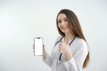 Young woman doctor is shock and showing green screen or copy space on her smartphone. . High quality photo