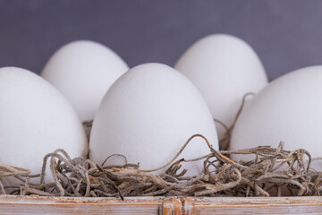 Close-Up of five eggs lying in a basket with gras.