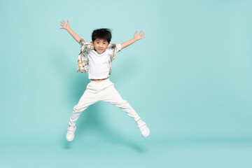 Asian little boy in flower pattern summer outfits jumping isolated on green background, Five years old - 583201628