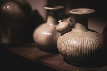 Closeup of ancient vases on a shelf at the exhibit of the National Museum of Singapore.