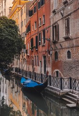 Vertical shot of a gondola moored on the shore of the canal in Venice, Italy
