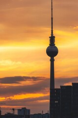 Fototapeta premium Vertical shot of the TV Tower against a cloudy sunset sky in Berlin, Germany