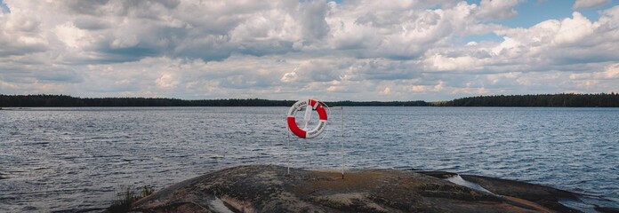 Closeup of a  lifebuoy ring at the beach on a view of the blue sea