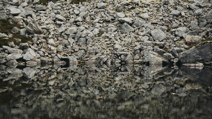 Close-up of a perfect reflection of stones in smooth water, for backgrounds