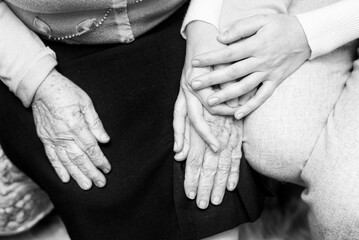 A pensioner is held by the hands, caring for her in old age. Holding hands as a symbol of support and sympathy