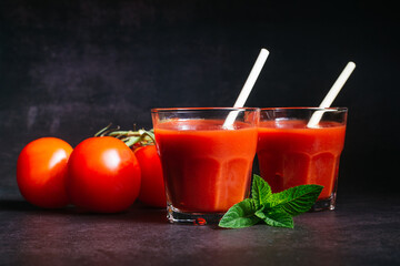 The glasses of tomato juice and a tomatos