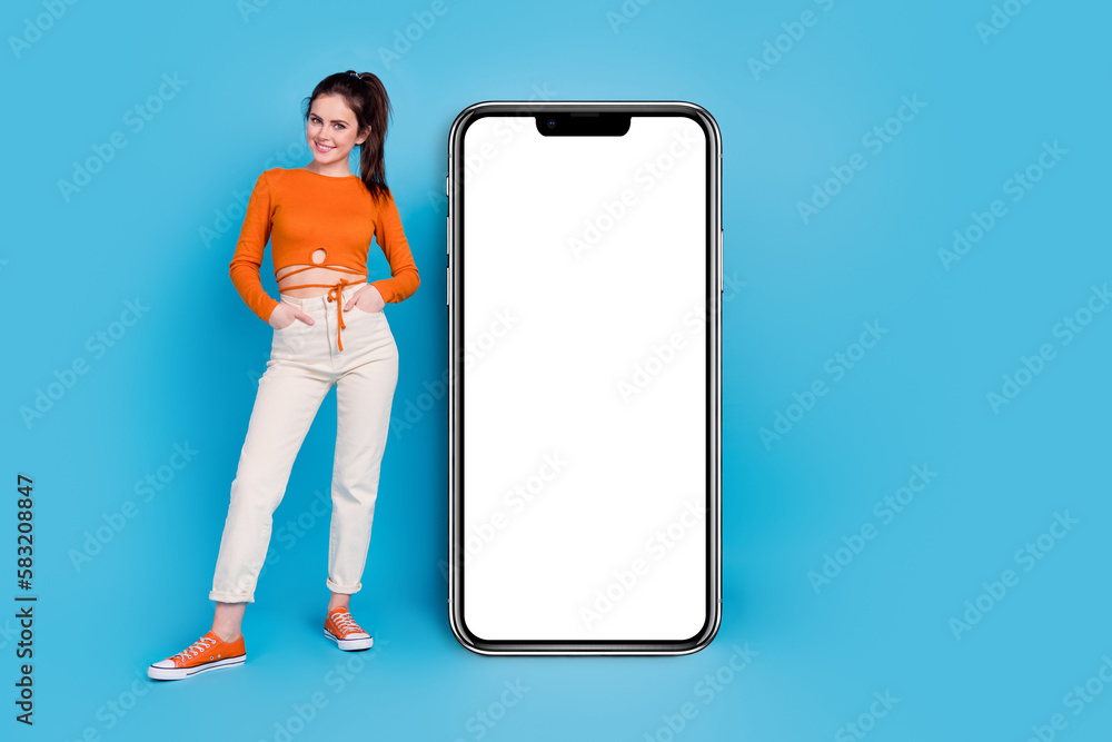 Sticker Full size photo of nice young brunette lady stand near promo wear top trousers footwear isolated on blue background