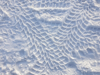 Tire tracks in snow, close-up. Car track in fresh snow. Winter tire marks in the snow.
