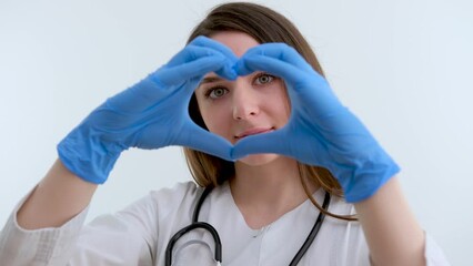 Beautiful young African American nurse or doctor with stethoscope stands, looking to the right side wearing blue scrubs and long curly hair