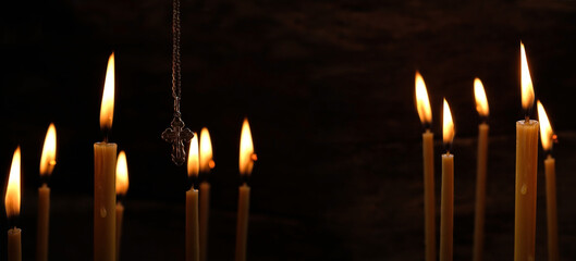 burning Church candles and Orthodox cross on dark abstract background. Religious, mourning concept. We Remember, mourn. symbol of Lent, Easter, Faith in God, Prayer. banner. copy space