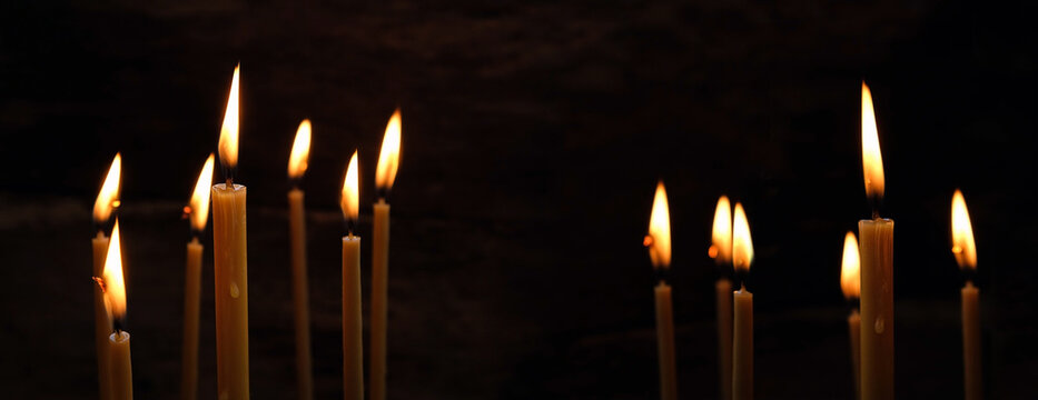 Burning wax candles on abstract black background. candle flame - Symbol of prayer, memory, Lent, Easter, Faith in God, mourning. banner. template for design. copy space