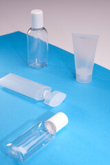 Closeup of plastic cosmetics containers against a bright background. Unbranded skincare and hygiene product bottles.