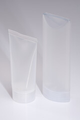 Closeup of plastic cosmetics containers against a bright background. Unbranded skincare and hygiene product bottles.