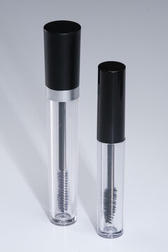 Unbranded eyeliner containers. Empty mascara bottles and applicator brushes.