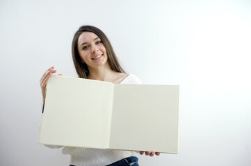 Naklejka premium Beautiful cute girl holding a white card isolated over white. High quality photo