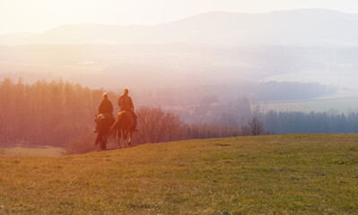 Man and woman, pair riding on horse in morning misty fog with sunrise. Romantic, realax hobby background