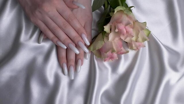 Beautiful hands of a young woman with wite manicure on nails.