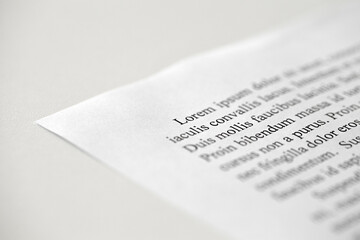 Lorem Ipsum dolor text on printed on paper in black and white, sample of document, side view,...