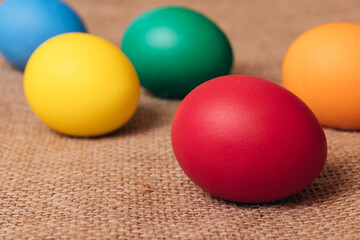 Painted eggs. Colorful Easter eggs on sackcloth. Macro shot, selective focus.