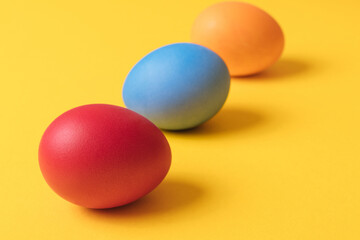 Colorful painted eggs on yellow background. Concept scene. Easter eggs. Selective focus. Macro shot.