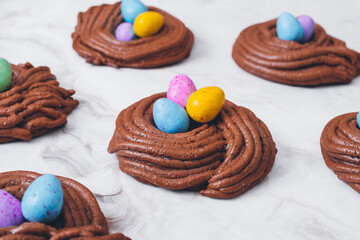 Easter nest cookies. Nest shape cookies with multicolored easter eggs in the center. Easter eggs covered by colorful candy shell.  Baked chocolate nests cookies.