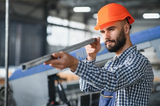 Factory worker measures the metal profile