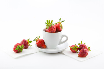 Ripe red strawberries in a cup on a white background