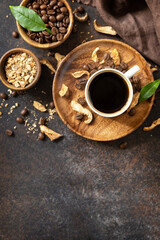 Mushroom coffee in a cup and coffee beans, trendy drink on a stone background. Healthy organic energizing adaptogen. View from above. Copy space.