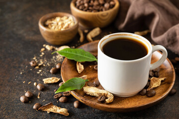 Healthy organic energizing adaptogen. Mushroom coffee in a cup and coffee beans, trendy drink on a stone background. Copy space.