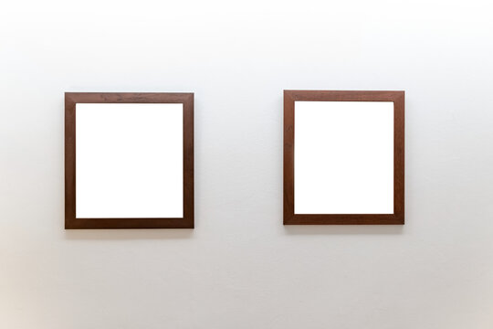 Blank wooden picture frames on concrete wall