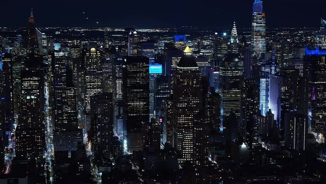 Aerial View of Famous Skyscraper Streets and Avenues at Night in Midtown Manhattan. Times Square. High Quality Footage Shot from Helicopter. New York City, United States.
