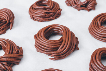 Cacao dough for cookies, dough in the shape of a circle or a nest on parchment paper. Preparing process to baking.