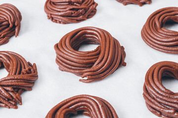 Cacao dough for cookies, dough in the shape of a circle or a nest on parchment paper. Preparing process to baking.