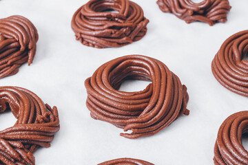 Cacao dough for cookies, dough in the shape of a circle or a nest on parchment paper. Preparing process to baking.