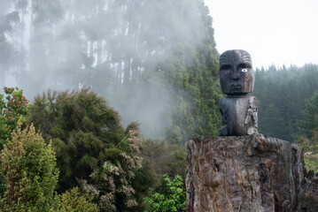 Maori tiki statue surrounded by mist in Waikato Aotearoa New Zealand in nature - obrazy, fototapety, plakaty