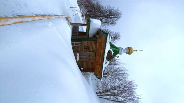 View of the chapel near the Belogorsky St. Nicholas Orthodox Missionary Monastery. Winter forest. The temple on the hill in winter. Russia, Perm Krai, Belaya Gora. 4K