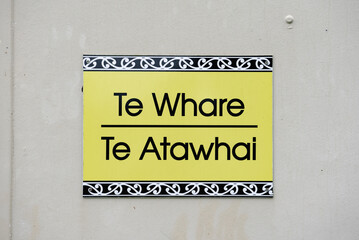 Te Whare Te Atawahi Maori and English Sign at local school in Waikato, Aotearoa, New Zealand - obrazy, fototapety, plakaty