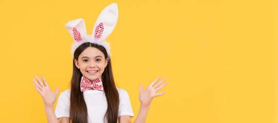 happy easter kid girl in bunny ears and bow tie hold carrot. Easter child horizontal poster. Web banner header of bunny kid, copy space.