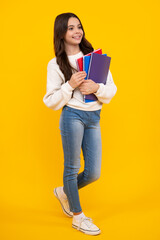 Back to school. Teenager schoolgirl with book ready to learn. School girl children on isolated yellow studio background. Happy face, positive and smiling emotions of teenager girl.