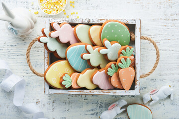 Fototapeta na wymiar Easter homemade gingerbread rabbits, carrots, chickens and eggs icing cookies. Festive holiday sweet food concept. Easter baking or decoration idea. White background, holiday concept with copy space