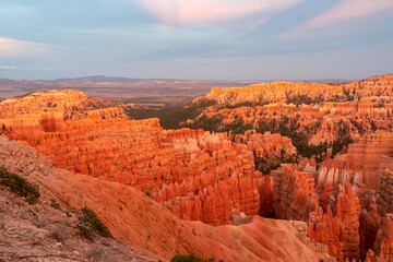 Aerial sunset view of massive hoodoo sandstone rock formation boat mesa in Bryce Canyon National Park, Utah, USA. Last sun rays touching on natural unique amphitheatre sculpted from red rock. Twilight