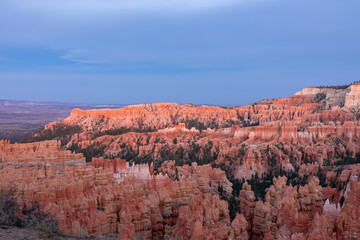Aerial sunset view of massive hoodoo sandstone rock formation boat mesa in Bryce Canyon National Park, Utah, USA. Last sun rays touching on natural unique amphitheatre sculpted from red rock. Twilight