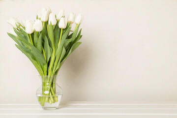 Tulip flowers in vase on wooden table
