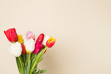 Tulip flowers in vase on wooden table, closeup view