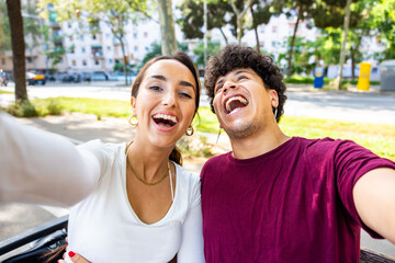 Happy couple taking a selfie laughing and having fun
