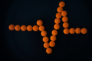 orange pills on a black background, vitamin C, heart pain pills, medicine, pharmacology, pharmacy, health